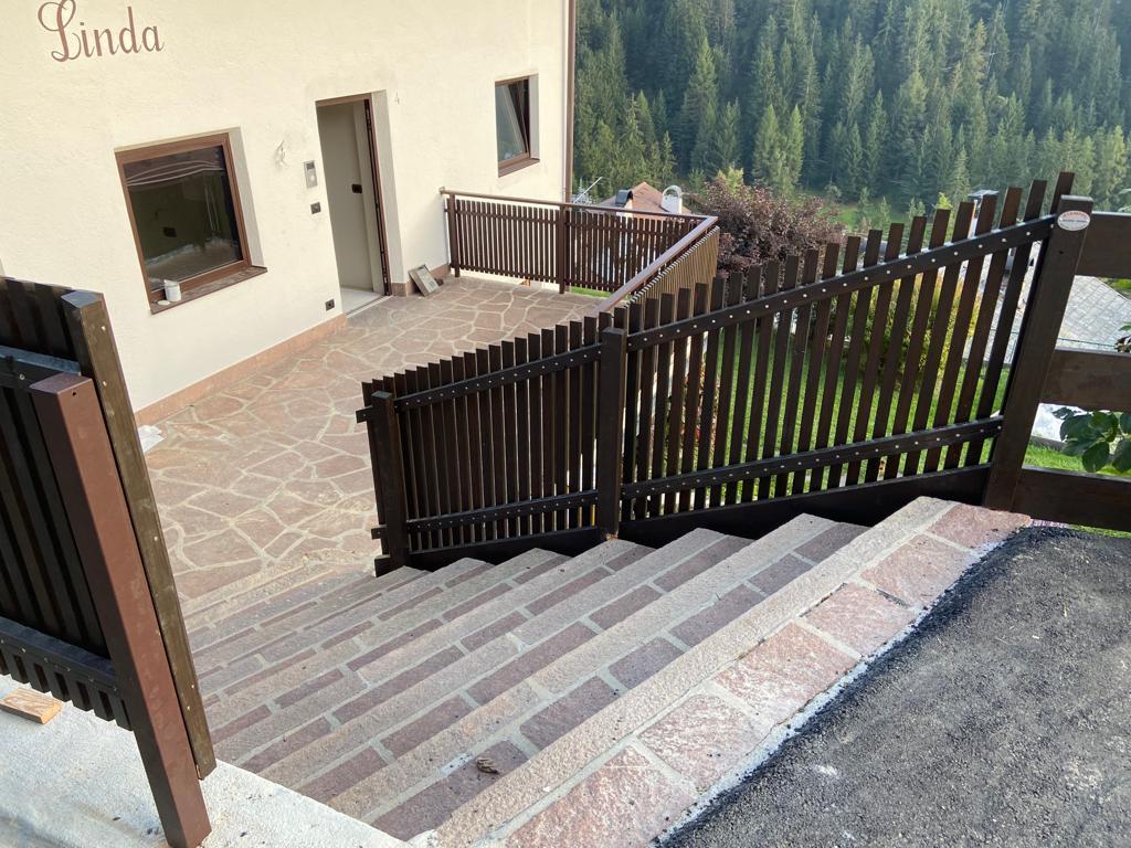 Stäbchenbalkon aus dunkel gestrichener Lärche mit Sockel und Lärchenholz-Handlauf