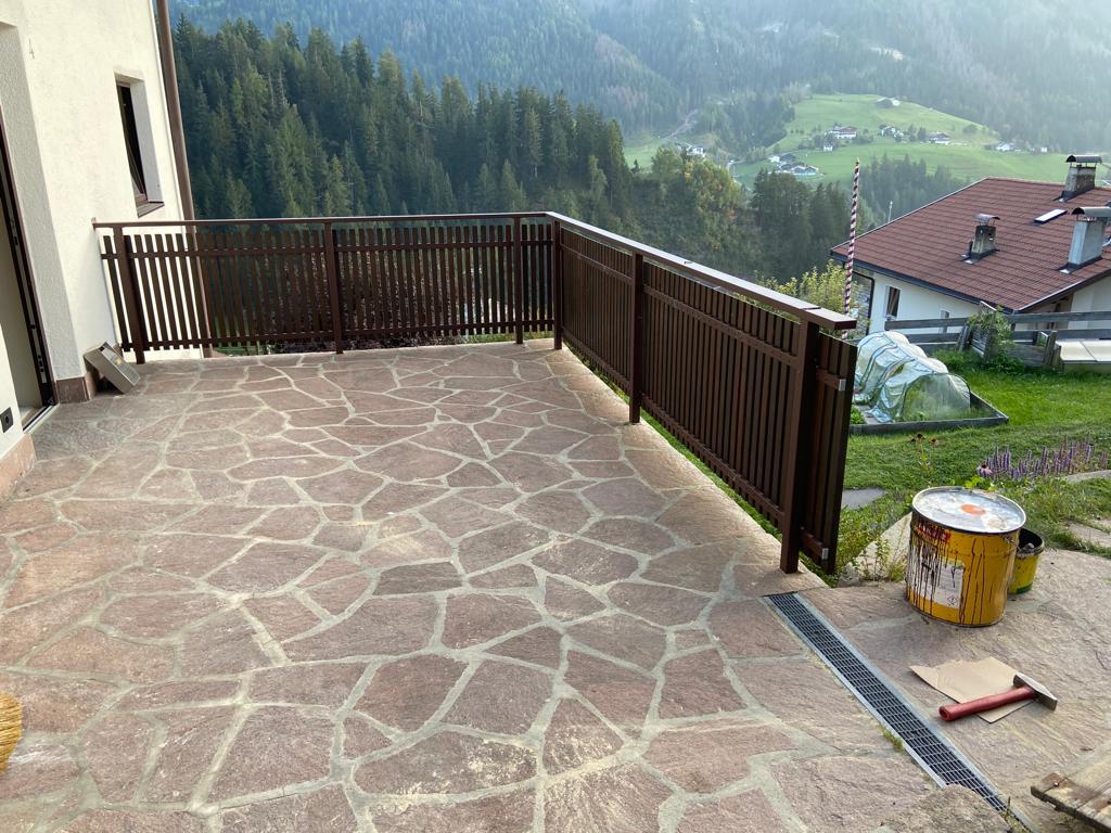 Stäbchenbalkon aus dunkel gestrichener Lärche mit Sockel und Lärchenholz-Handlauf