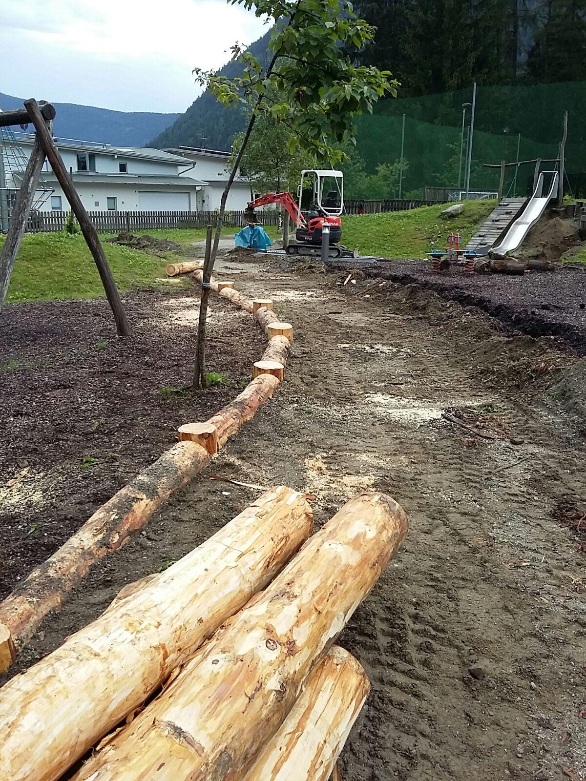 Spielplatzgestaltung mit entrindeten Rundhölzern und fester Verankerung im Boden
