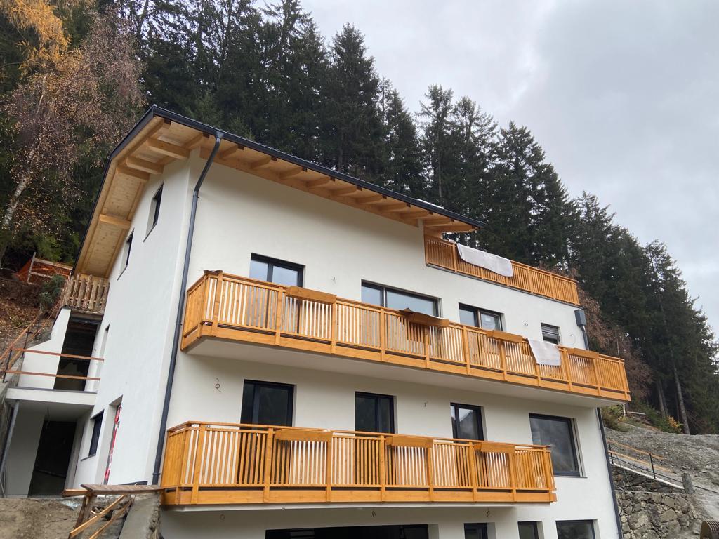  Fichten-Massivholz-Balkon mit 190 mm breiten Sockelfeldern, 40x40 mm Stäben, Lärchenholz-Handlauf und Einhängeblumentrögen